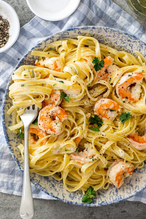 One-pot lemon garlic shrimp pasta served in a skillet with fresh parsley and lemon slices"